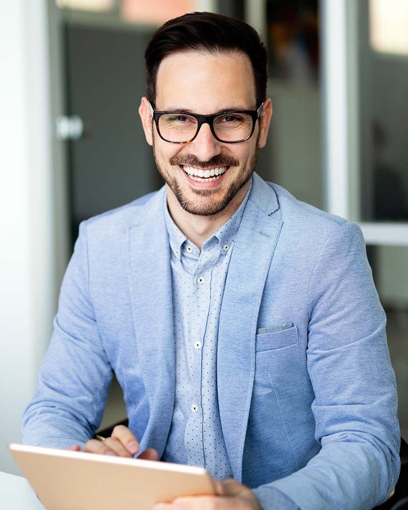 Portrait of handsome successful smiling businessman holding tablet