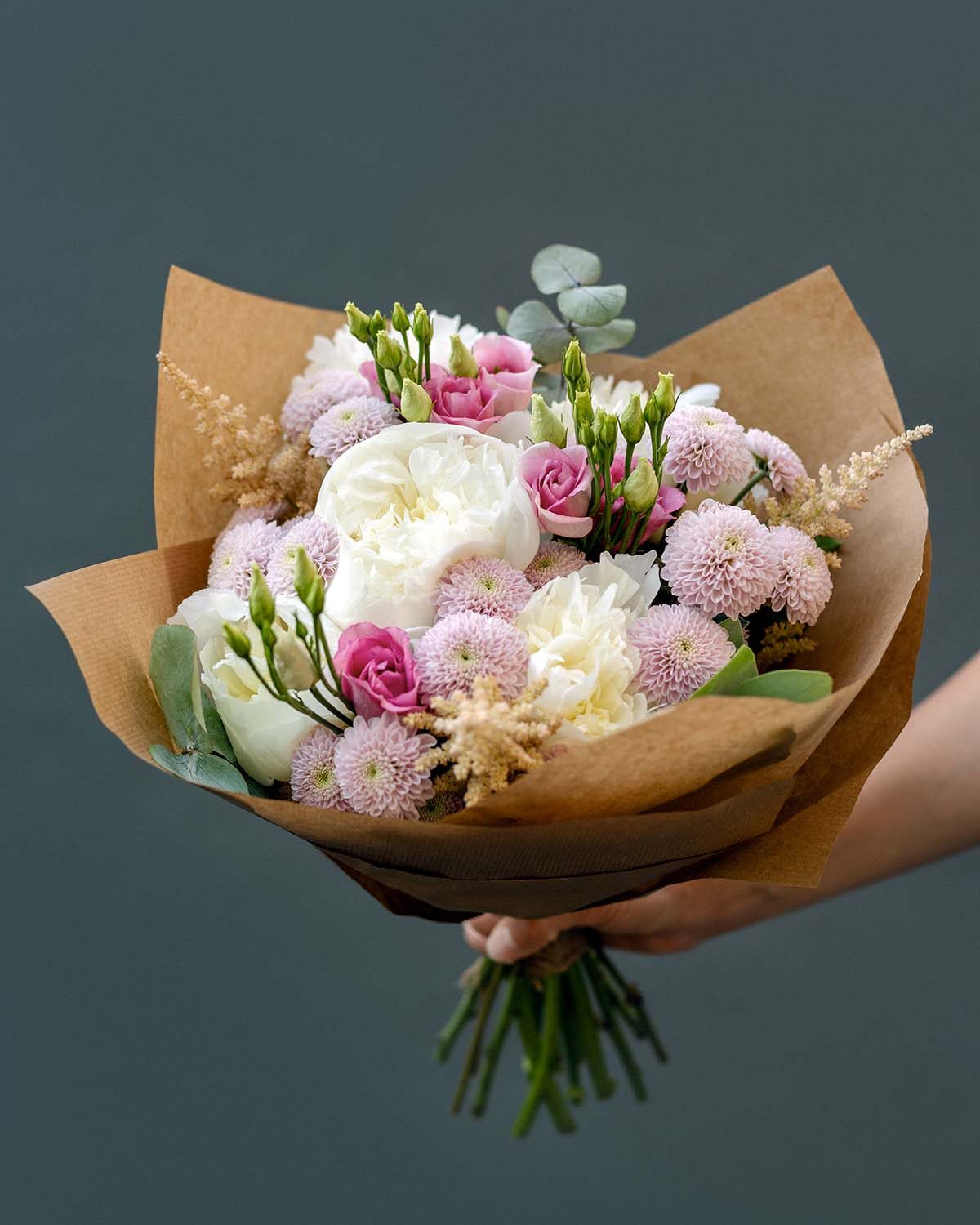 woman-s-hand-holds-a-bouquet-of-peonies-J6H8ARZ