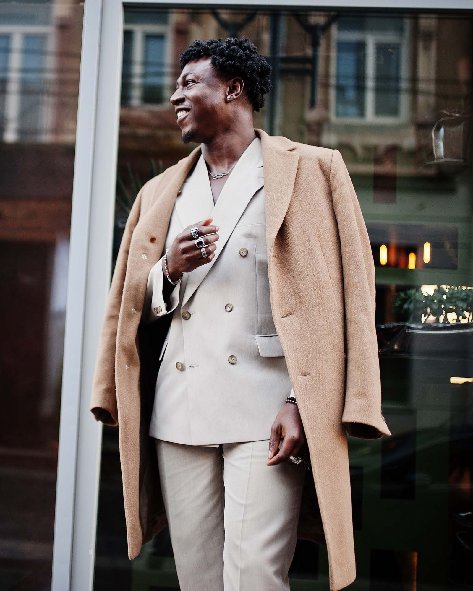 Stylish afro man in beige old school suit and coat. Fashionable young African male in casual jacket on bare torso.